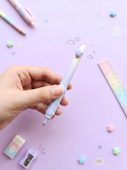 Hand holding a pastel-colored pen on a purple background with stationery items.