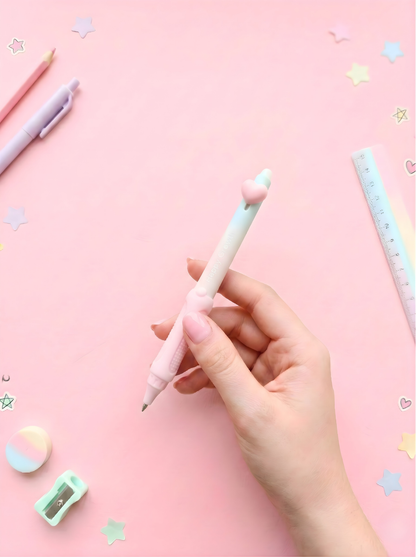 Hand holding a light blue pen on a pink background with stationery items.