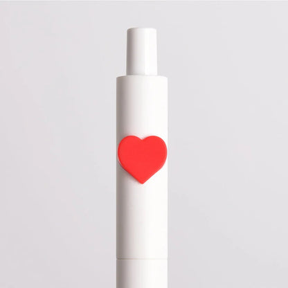 White cylindrical object with a red heart on a light gray background
