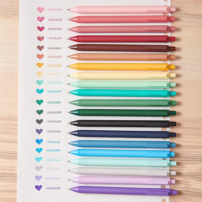 Colorful pens arranged in a gradient on a lined notebook page.