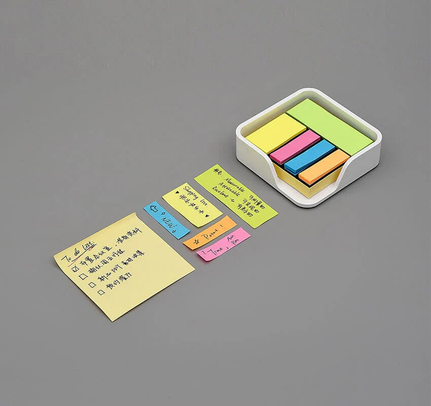 Colorful sticky notes with a holder on a gray background