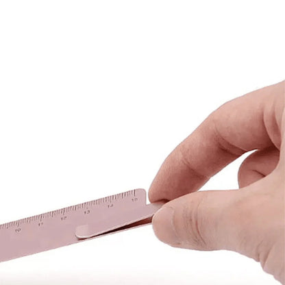 Hand holding a pink ruler against a white background